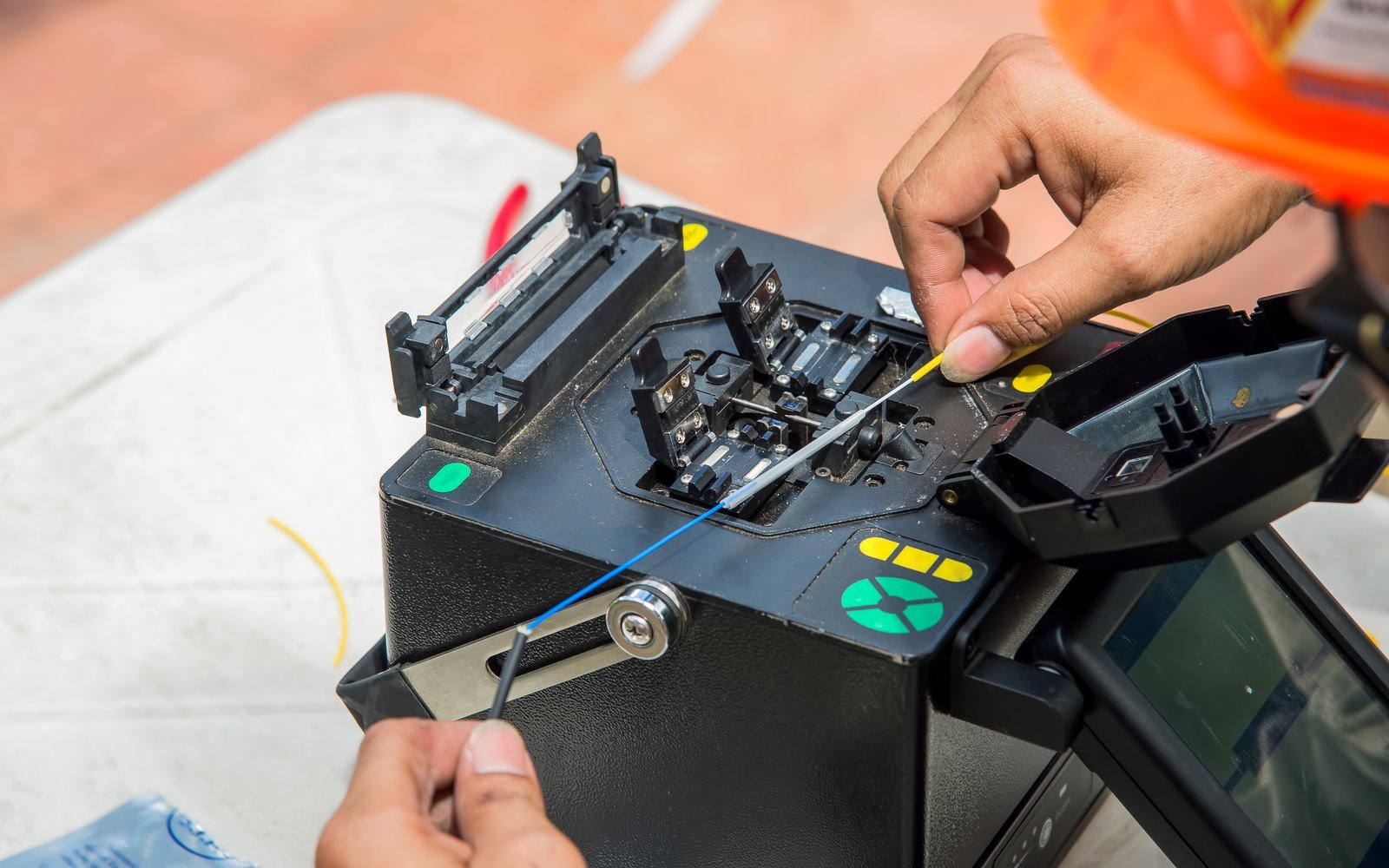 Técnico operando una fusionadora de fibra óptica